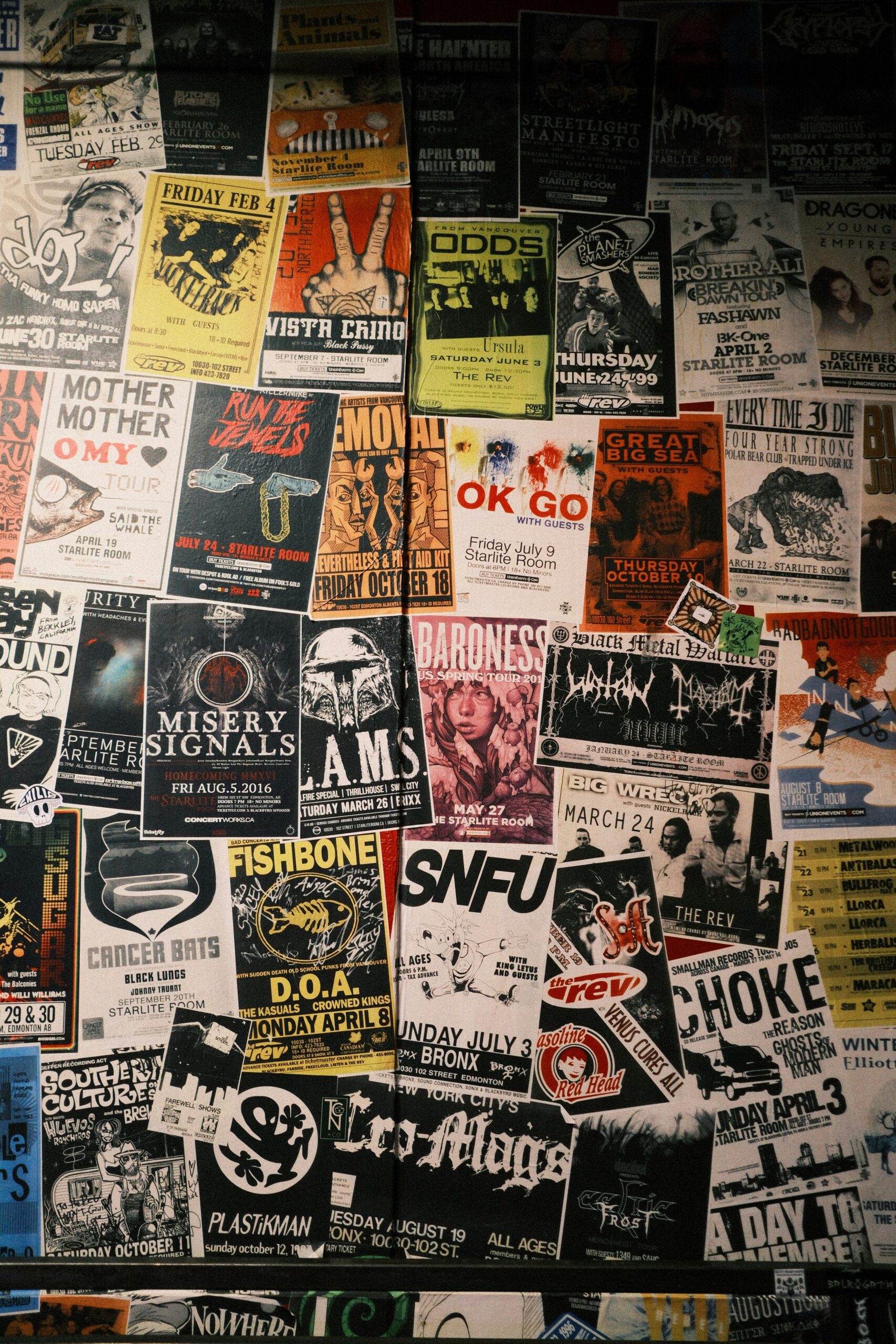 A wall covered edge to edge with overlapping gig and event posters