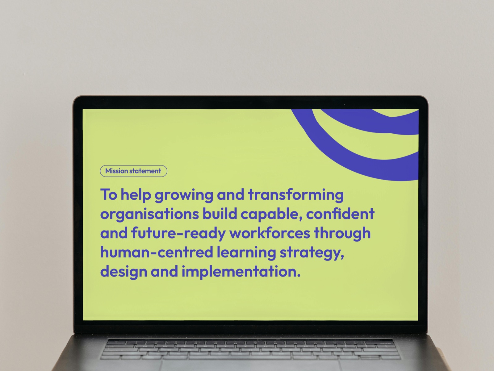 A laptop showing the Beyond mission statement slide in Beyond lime and violet